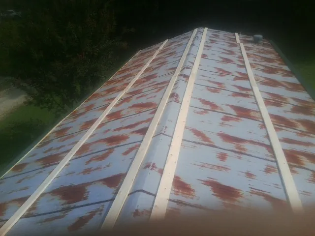 Rusted metal roof panels with new wood purlins before replacement — Storm Damage Roof Repair in Matamoras by Roofing Brothers