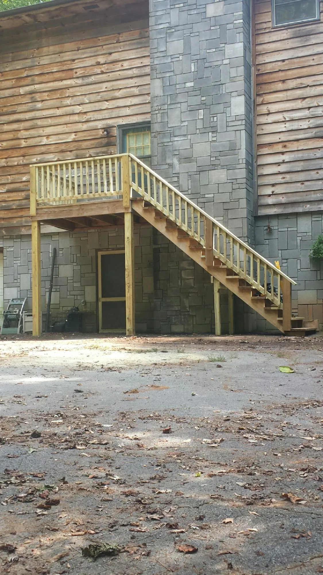 New pressure treated deck and stair landing on a log home in Matamoras