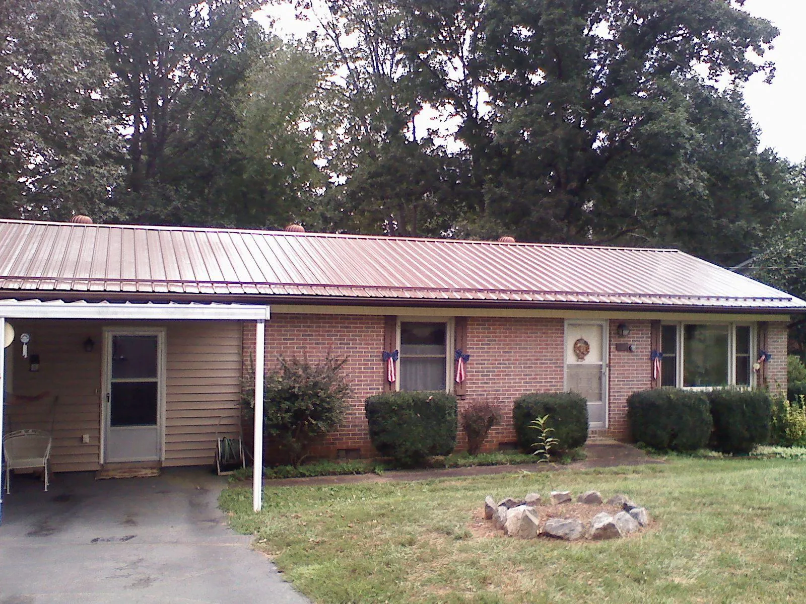 Bronze metal roof and carport on a brick ranch home — Roof Repair work by our crew in Matamoras