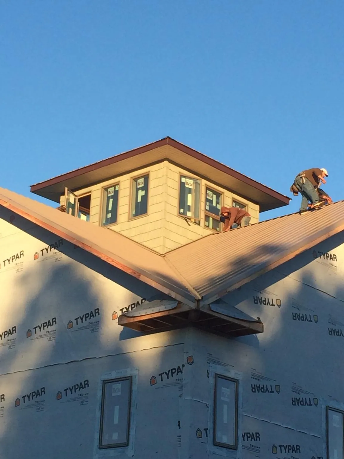 Roofers working around a rooftop cupola on a new metal roof at sunset — Roof Waterproofing in Matamoras by Roofing Brothers